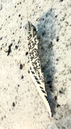 Single silver-plated Palestine pin with floral and geometric cutouts, displayed on a speckled stone surface.